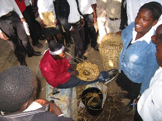 A group watching a basket being woven during a training session