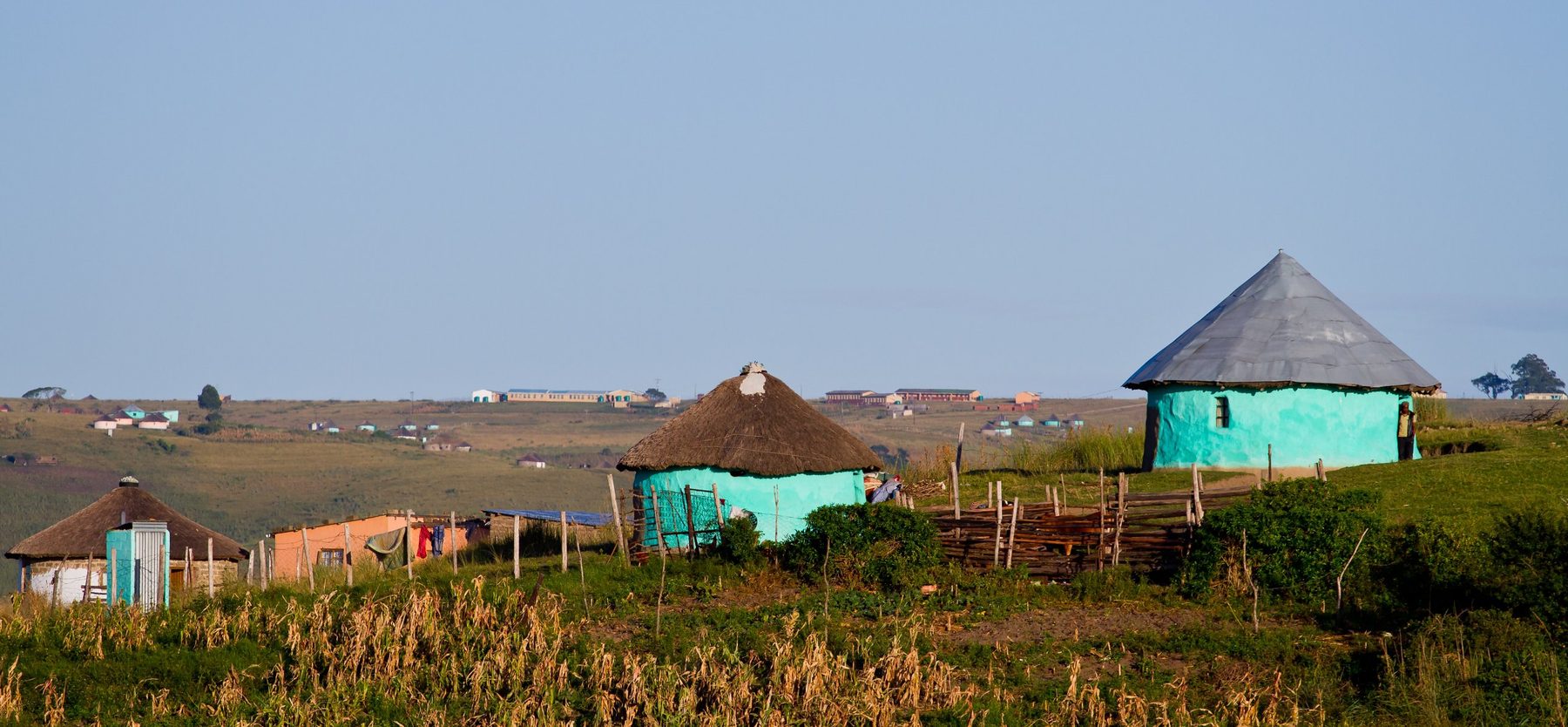 Painted rondavel homesteads on a green hillside